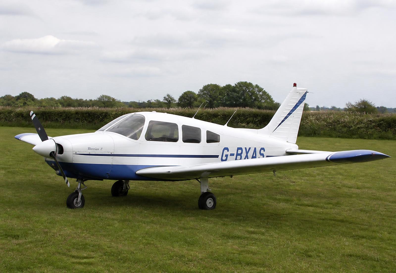 A four seat light aircraft parked on the grass runway at Vale Airfield